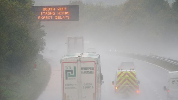 A weather warning sign alerts drivers travelling through water spray and winds on the M5 motorway network