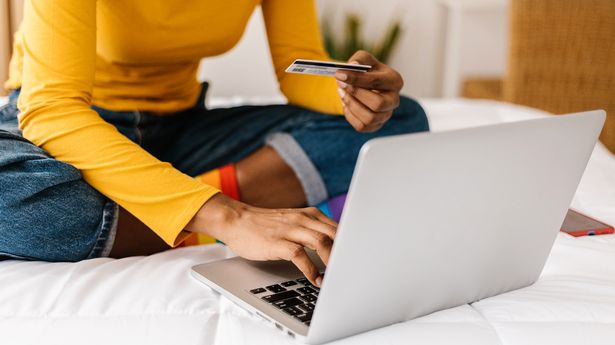 Close up woman hands using credit card to buy online on laptop