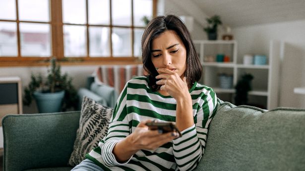 Worried woman looking at her phone