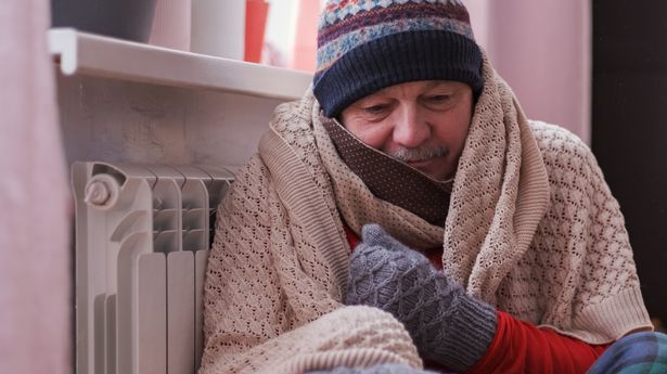 Man feeling cold at home having problems with home heating