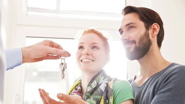 Young couple receiving apartment key from landlord or real estate agent, Germany