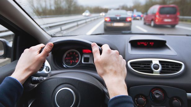 driving car on highway, close up of hands on steering wheel